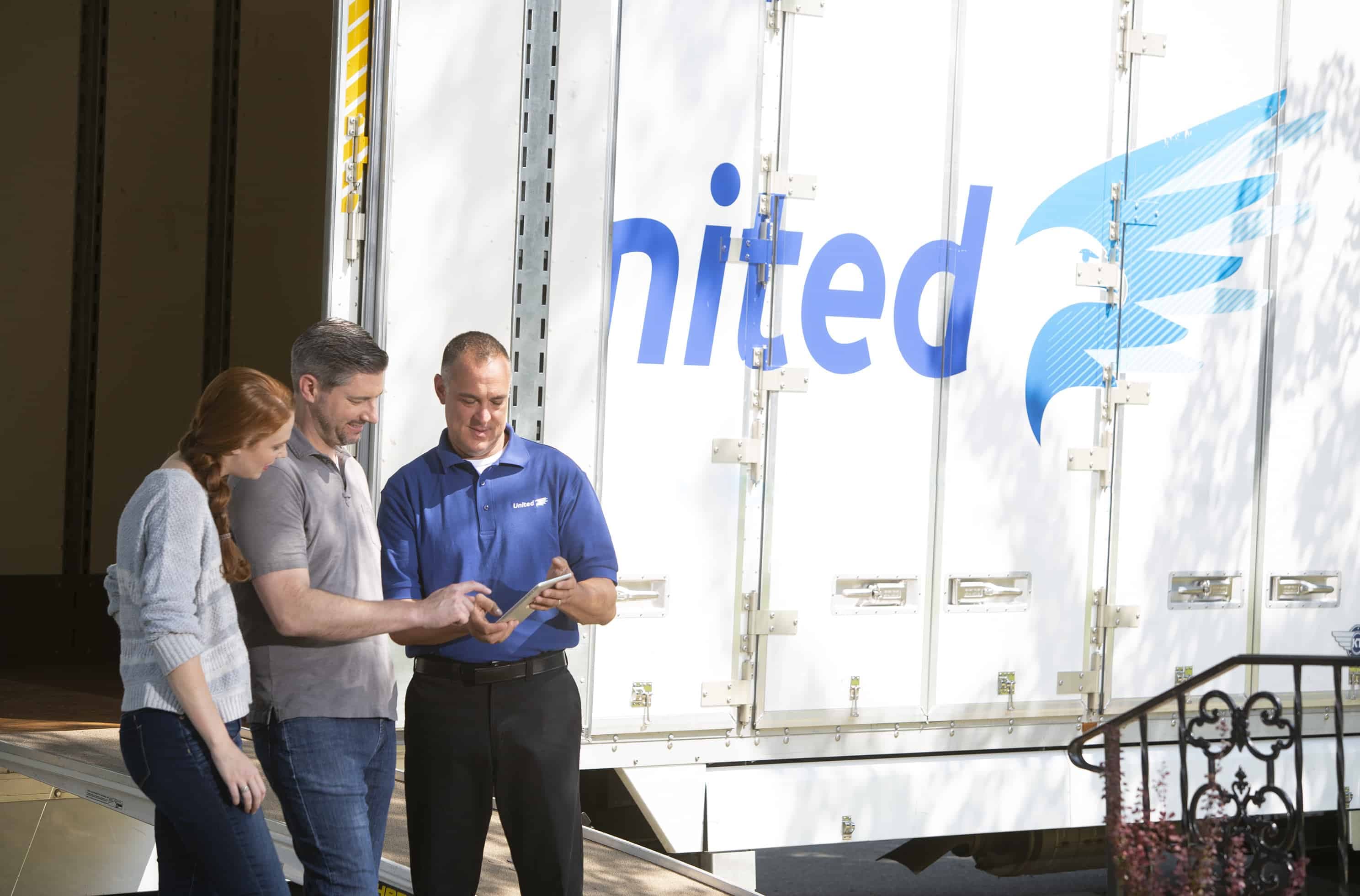 Moving Glossary - two home owners with a United Van Lines agent next to a moving truck - United Van Lines