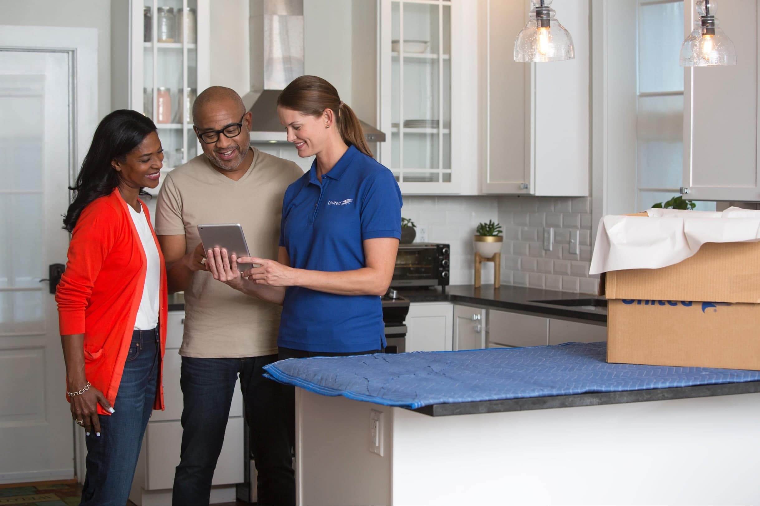 America's #1 Moving Company - A couple and their moving agent discussing their move in a their kitchen - United Van Lines